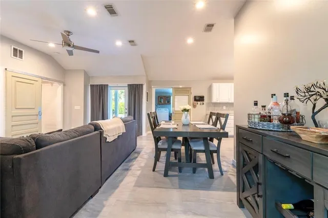 a living room with furniture a dining table and chairs with kitchen view