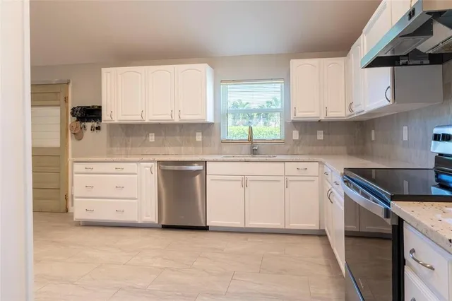 a kitchen with white cabinets stainless steel appliances and sink