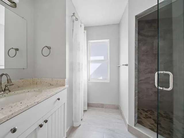 a bathroom with a granite countertop sink mirror and vanity