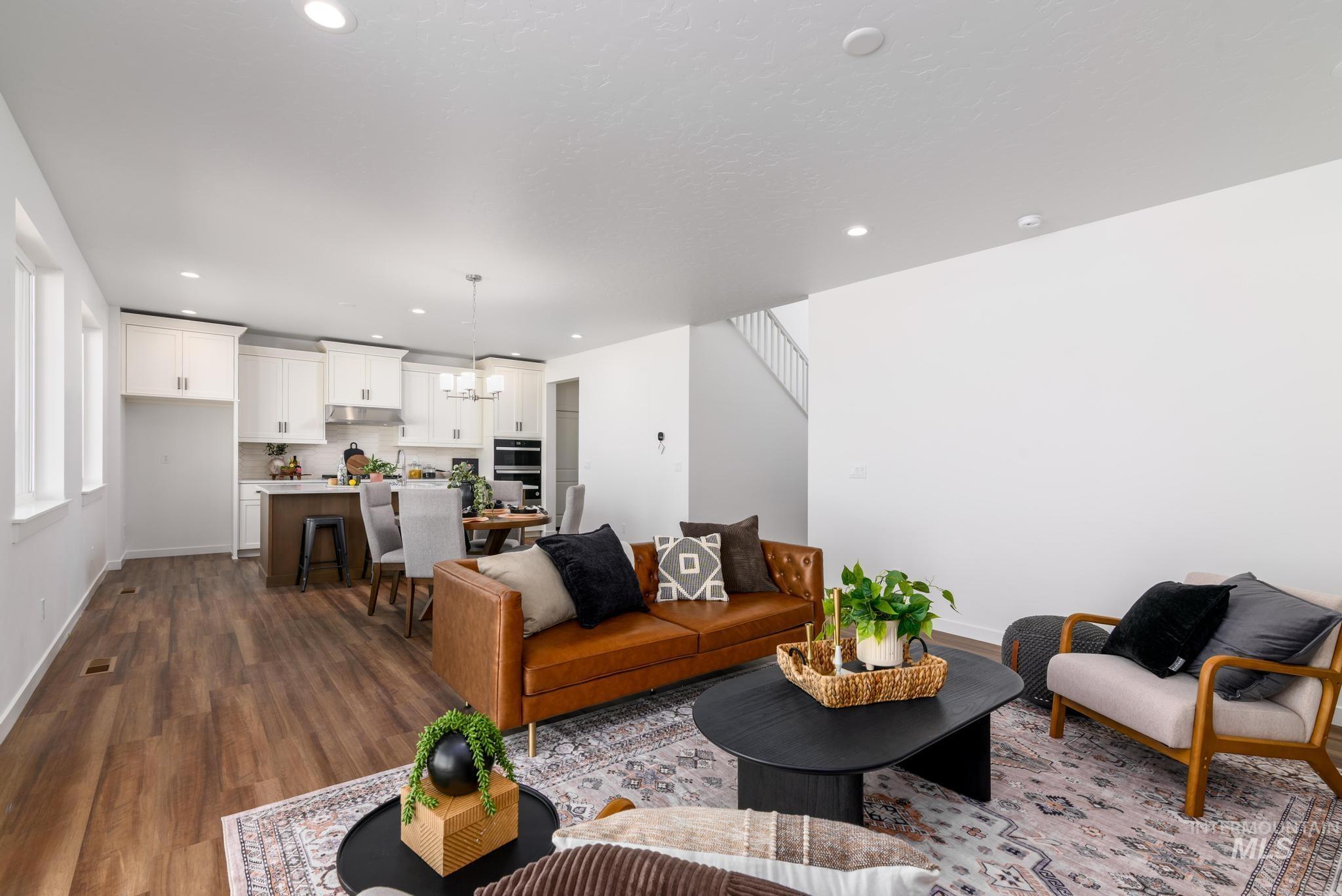 6049 West Snow Currant Street Meridian, ID 83646 - Photo 2 of 12 Living area with dark wood-style floors and a chandelier