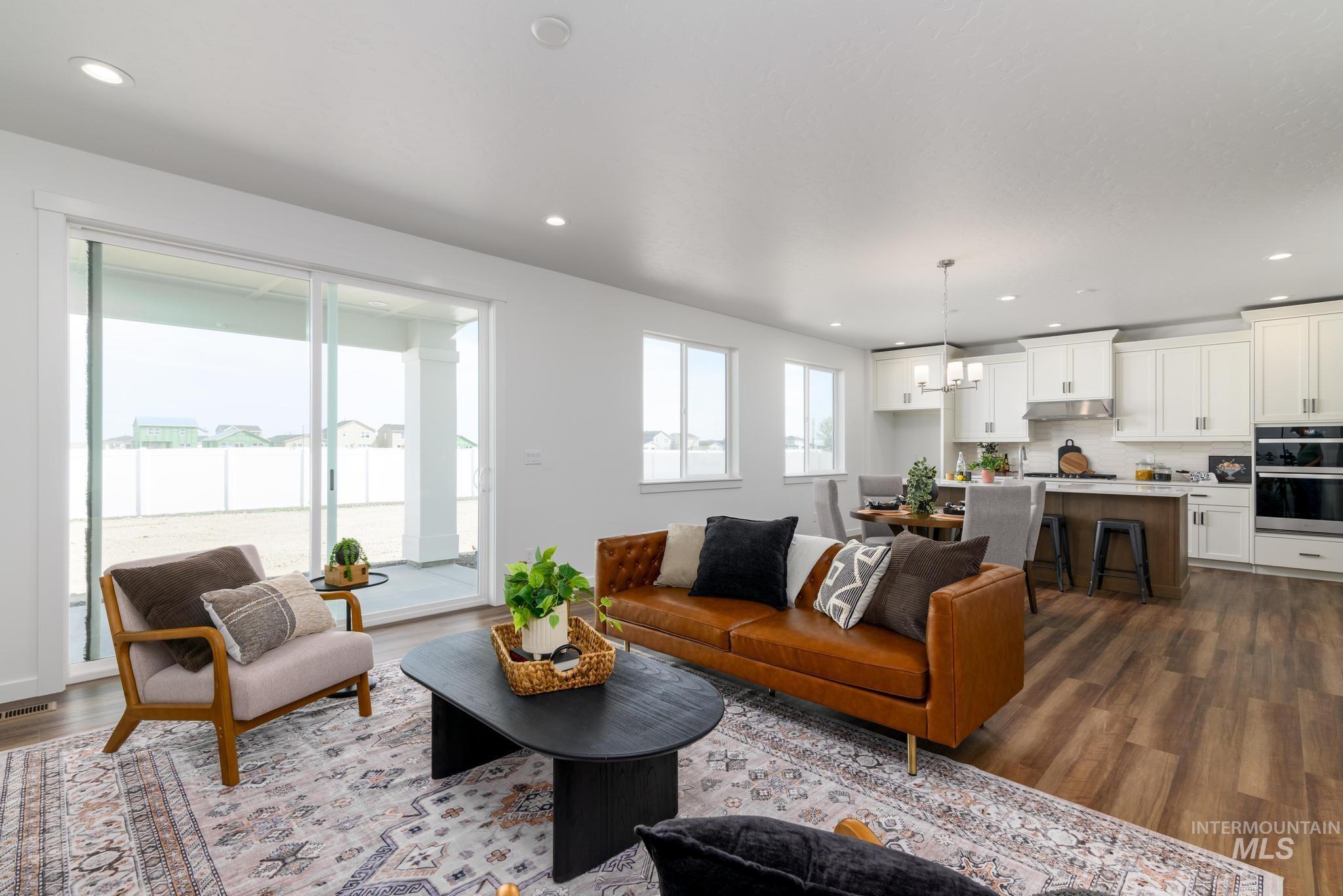 6049 West Snow Currant Street Meridian, ID 83646 - Photo 3 of 12 Living room featuring dark wood finished floors and a chandelier