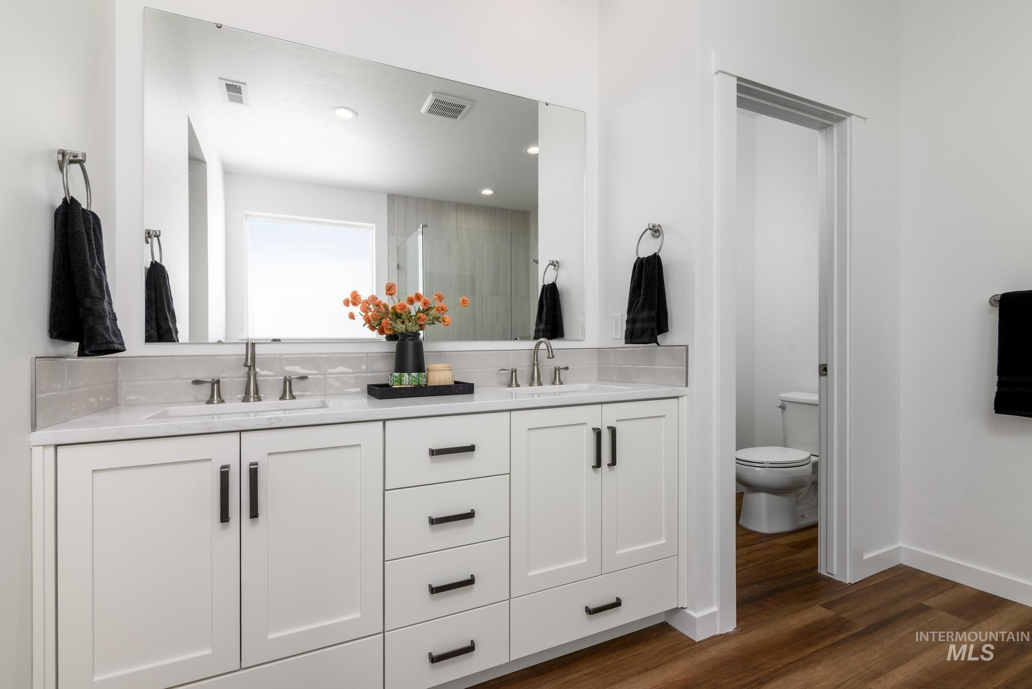 6049 West Snow Currant Street Meridian, ID 83646 - Photo 9 of 12 Bathroom with double vanity, a stall shower, dark wood-style flooring, and recessed lighting