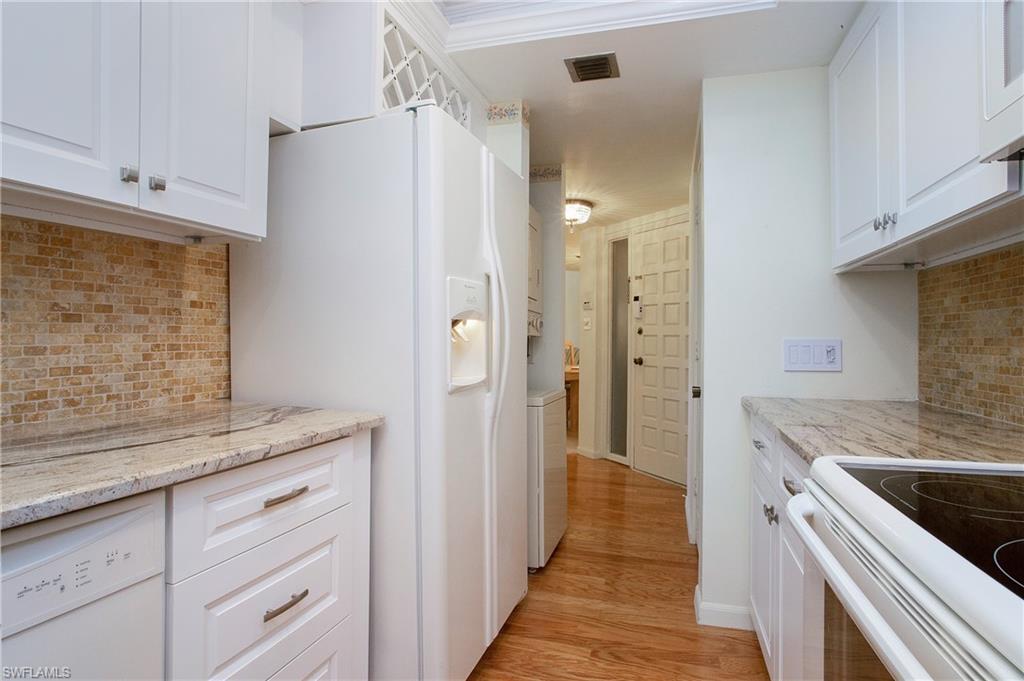 955 Palm View Drive, Unit B307 Naples, FL 34110 - Photo 13 of 25 a kitchen with a sink and a refrigerator