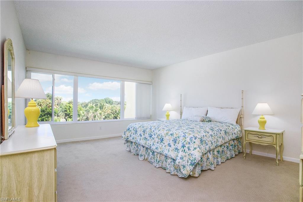955 Palm View Drive, Unit B307 Naples, FL 34110 - Photo 14 of 25 a bedroom with a bed table and a window