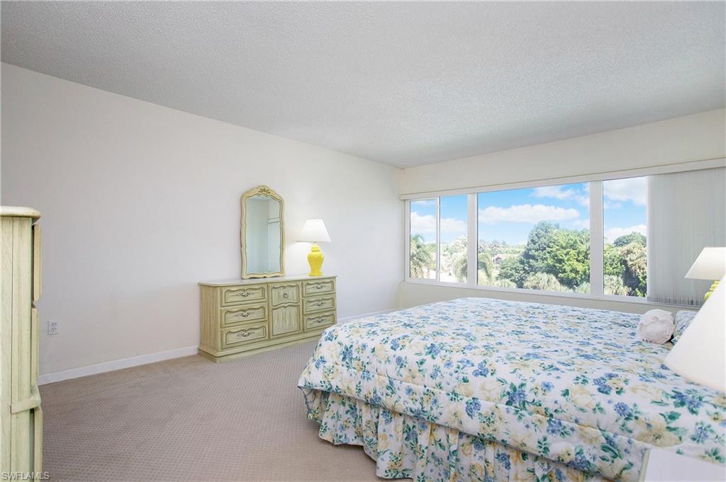 955 Palm View Drive, Unit B307 Naples, FL 34110 - Photo 15 of 25 a bedroom with a bed and window