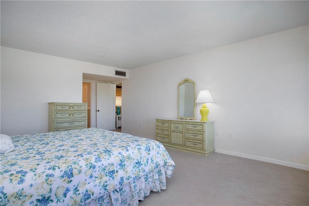 955 Palm View Drive, Unit B307 Naples, FL 34110 - Photo 17 of 25 a bedroom with a bed and painting on the wall