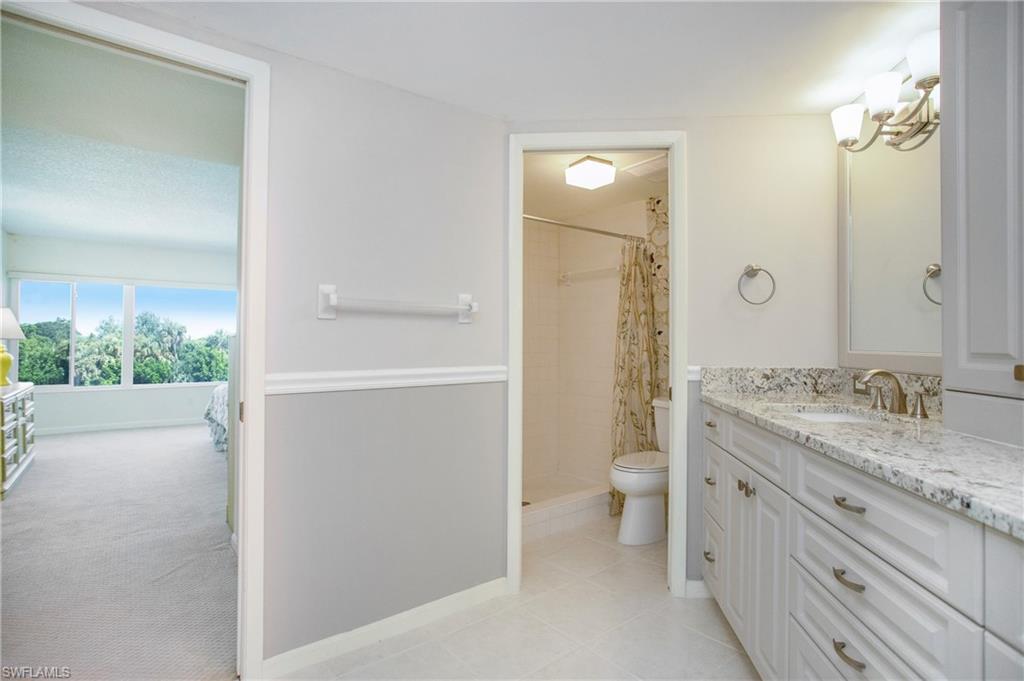 955 Palm View Drive, Unit B307 Naples, FL 34110 - Photo 19 of 25 a bathroom with a granite countertop sink toilet and shower