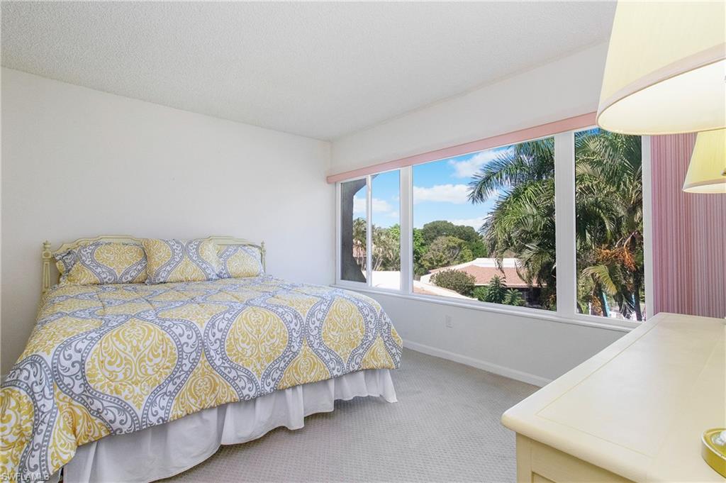 955 Palm View Drive, Unit B307 Naples, FL 34110 - Photo 20 of 25 a bedroom with a bed and a large window