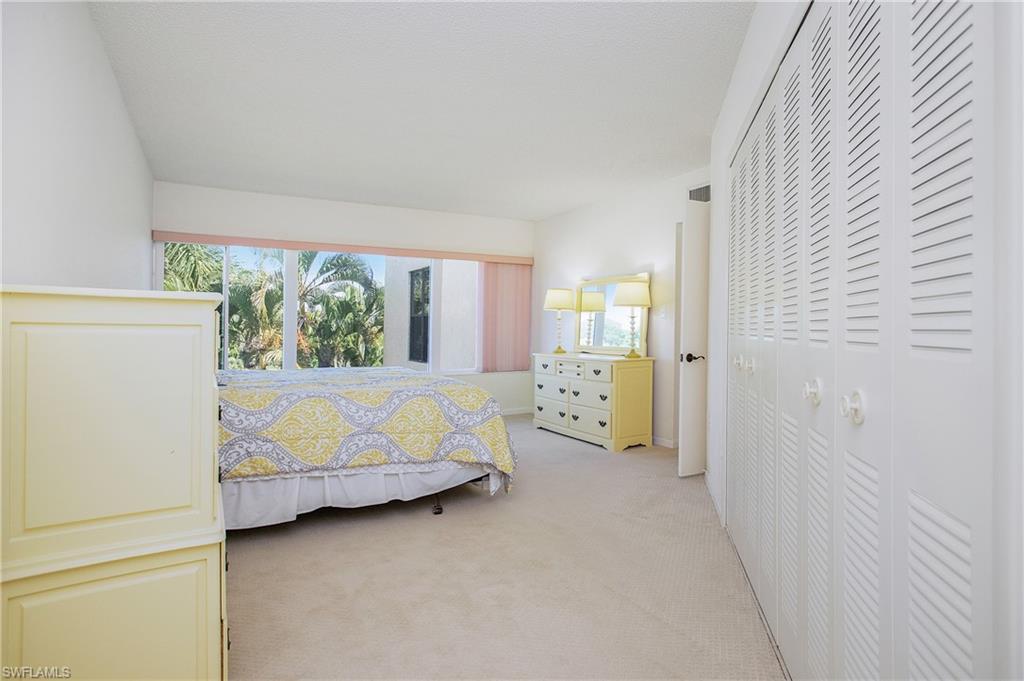 955 Palm View Drive, Unit B307 Naples, FL 34110 - Photo 22 of 25 a bed room with a bed and a couch