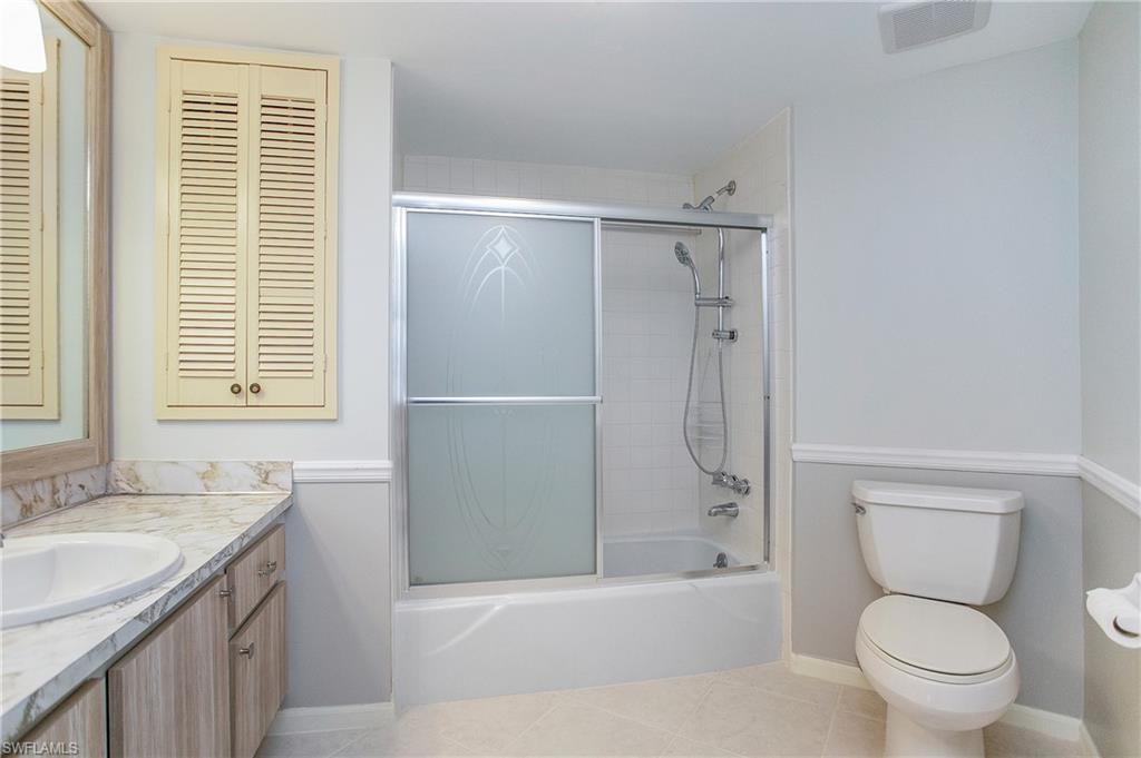 955 Palm View Drive, Unit B307 Naples, FL 34110 - Photo 23 of 25 a bathroom with a granite countertop toilet a sink and a bathtub