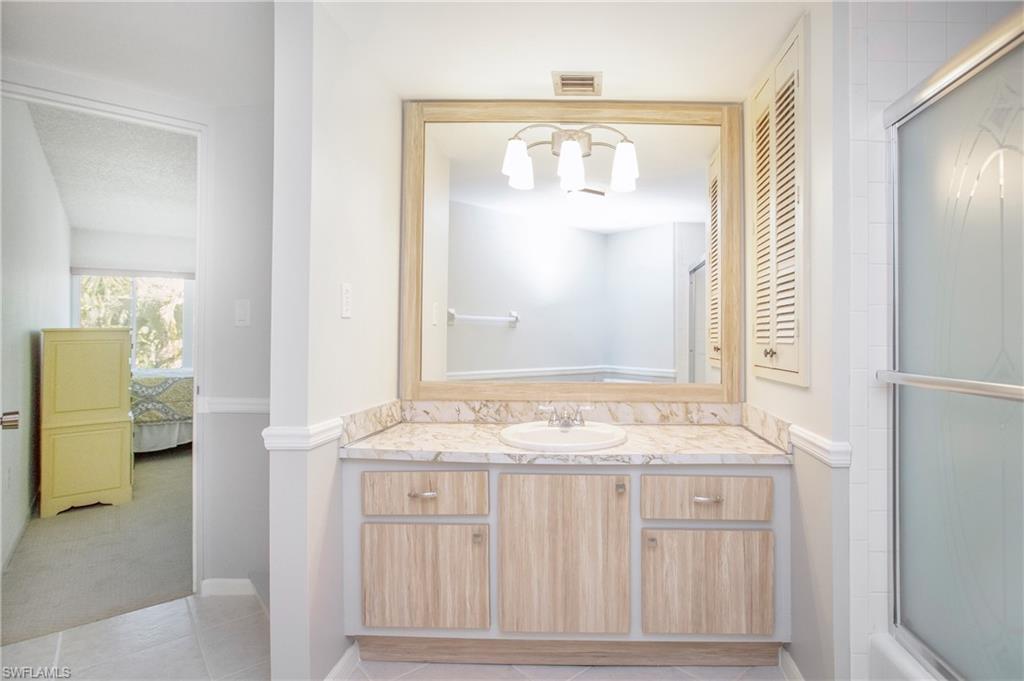 955 Palm View Drive, Unit B307 Naples, FL 34110 - Photo 24 of 25 a bathroom with a granite countertop sink and a mirror