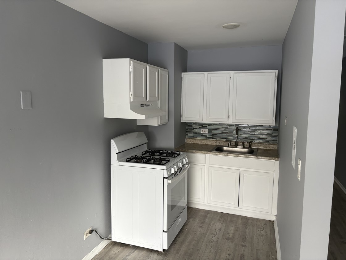 1930 South Cicero Avenue, Unit 208 Cicero, IL 60804 - Photo 3 of 9 a kitchen with a stove a sink and white cabinets