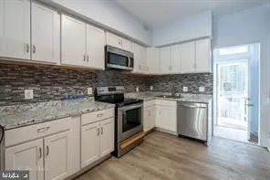 a kitchen with white cabinets stainless steel appliances and sink