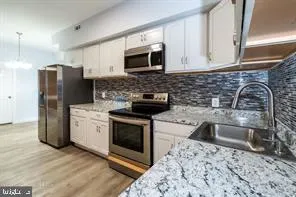 a kitchen with granite countertop a sink stove and refrigerator