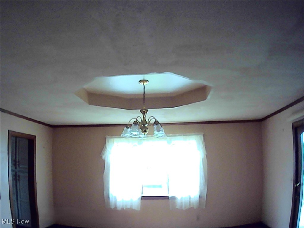 10102 Joppa Road Vermilion, OH 44089 - Photo 6 of 20 Details featuring an inviting chandelier, a tray ceiling, and crown molding