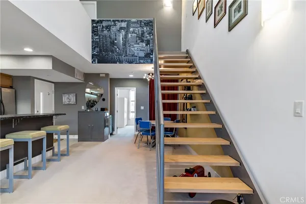 a view of a hallway to room with wooden floor and windows