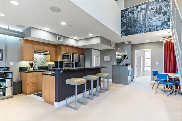 a kitchen with stainless steel appliances kitchen island granite countertop a refrigerator and a stove