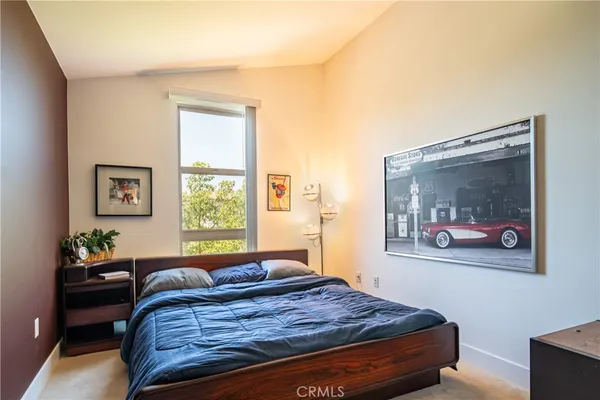 a bedroom with a bed and a painting on the wall