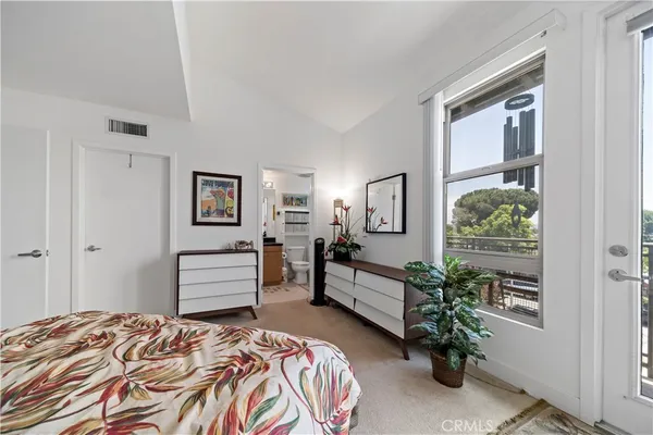a bedroom with a bed and a potted plant