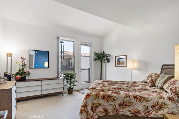 a bedroom with a bed potted plant and a window