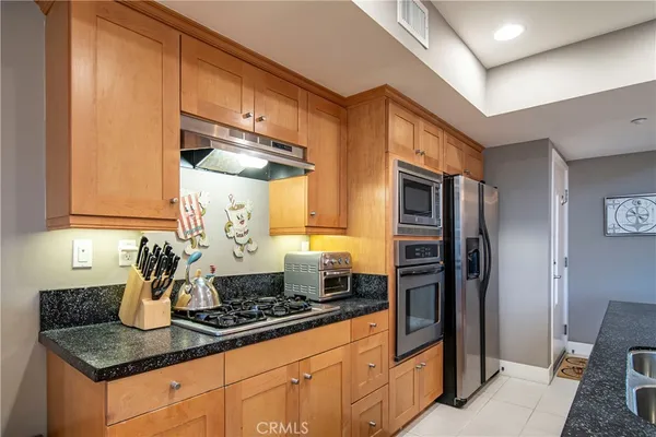 a kitchen with stainless steel appliances granite countertop a sink stove and refrigerator