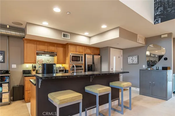 a kitchen with stainless steel appliances kitchen island granite countertop a sink and cabinets