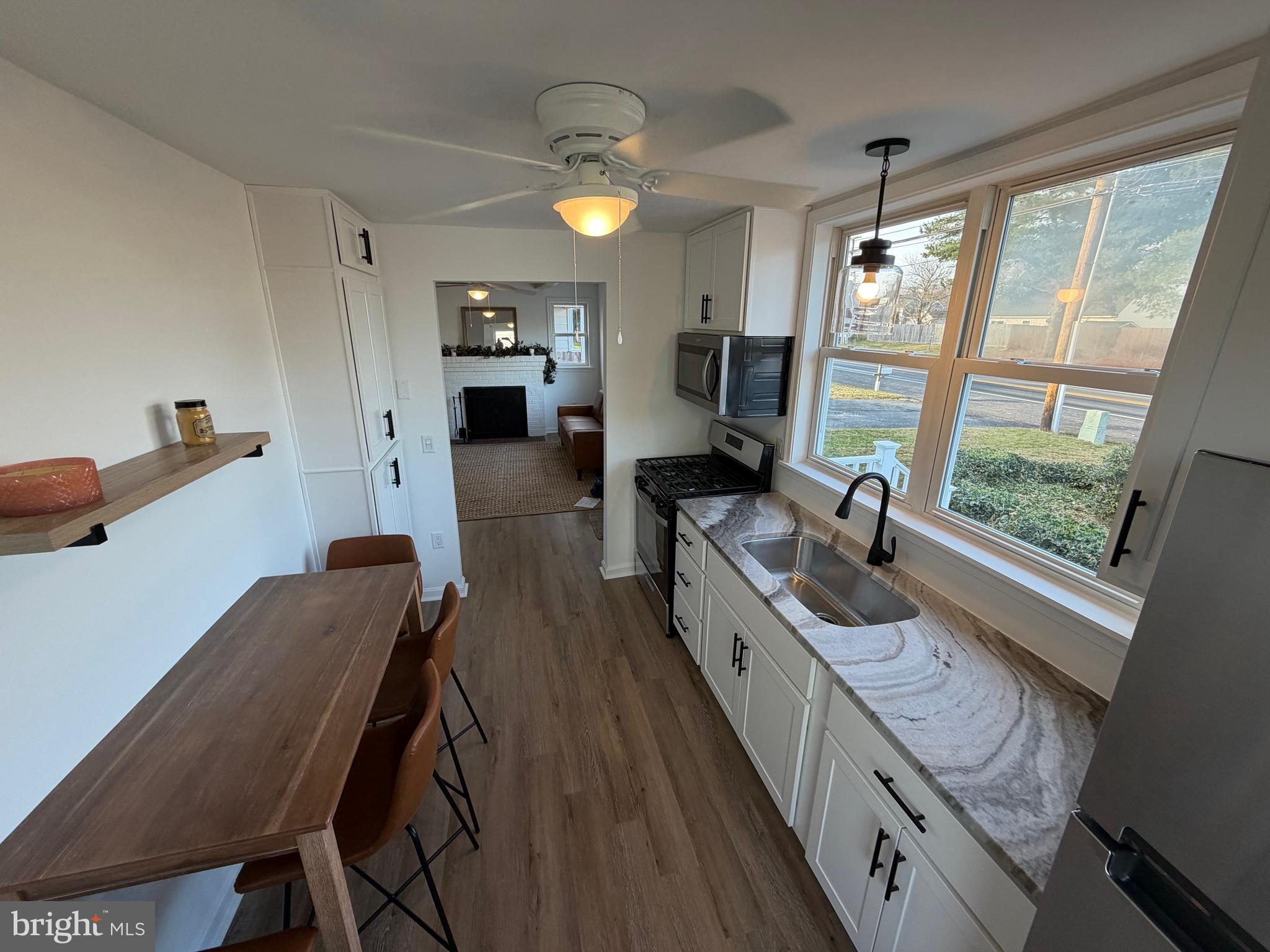 972 South Little Creek Road Dover, DE 19901 - Photo 9 of 22 a large kitchen with sink a refrigerator and chairs