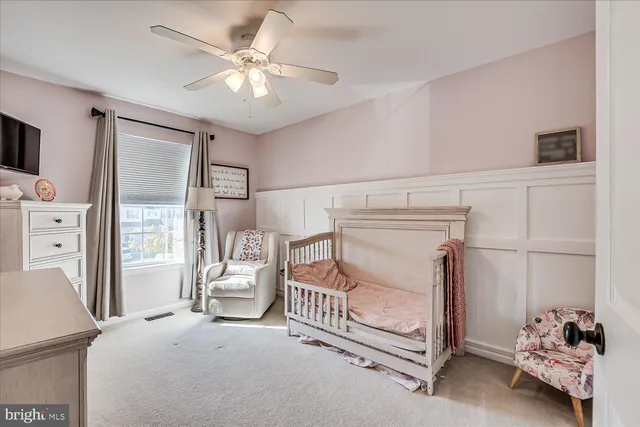 a bedroom with furniture and a chandelier fan