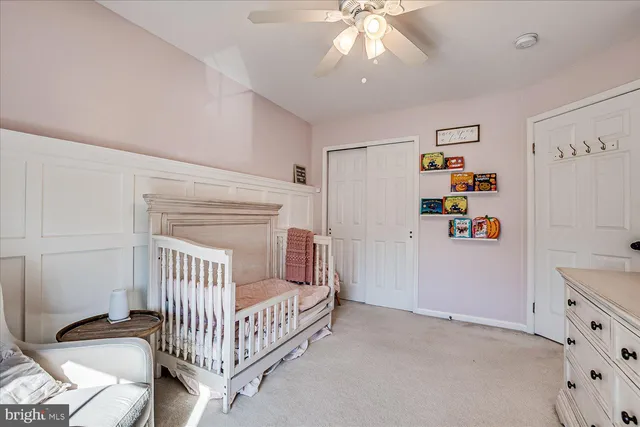 a view of a livingroom with a baby crib cabinets and a window