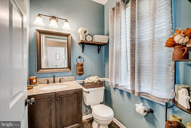 a bathroom with a sink vanity mirror and toilet