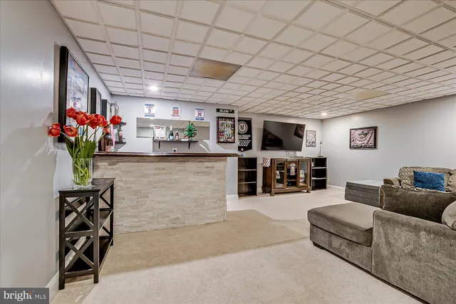 a living room with furniture potted plant and kitchen view