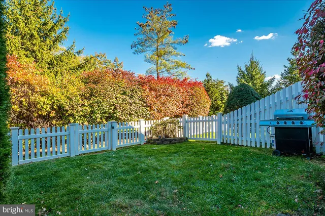 a view of a house with a small yard and wooden fence