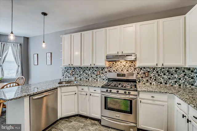 a kitchen with granite countertop white cabinets and white appliances