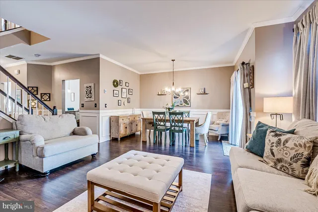 a living room with furniture a dining table and a large window
