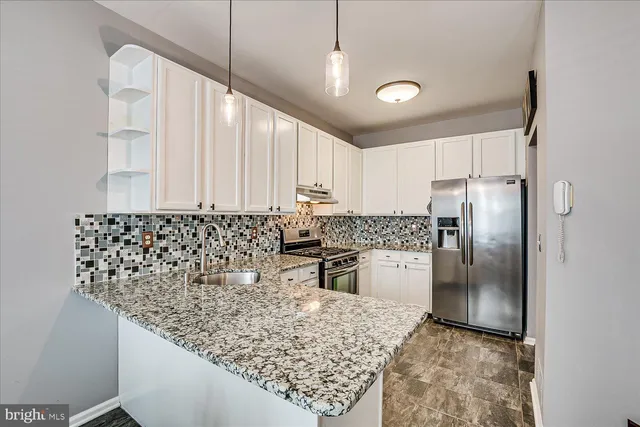 a kitchen with stainless steel appliances granite countertop a refrigerator sink and cabinets