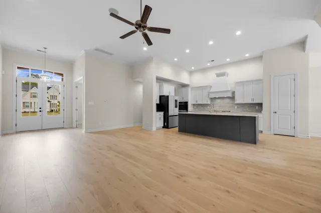 a view of an empty room with window and wooden floor