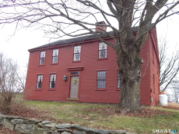 a red brick house with trees in front of it