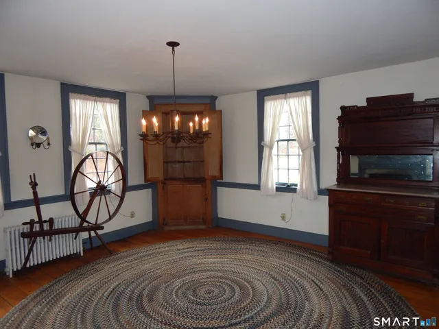 a view of an empty room with wooden floor and windows
