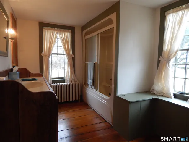 a dining room with a window and wooden floor