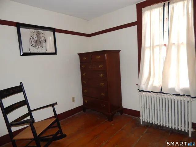 a view of a hallway with wooden floor and windows
