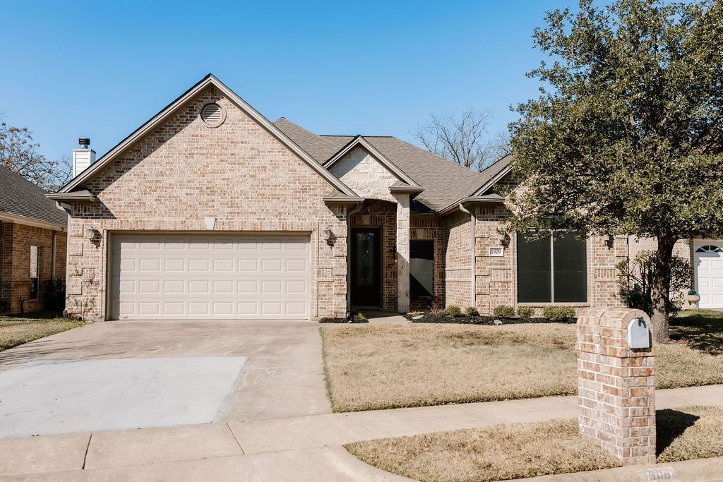 1909 Debbie Drive Bryan, TX 77802 - Photo 1 of 34 a front view of a house with a yard and garage