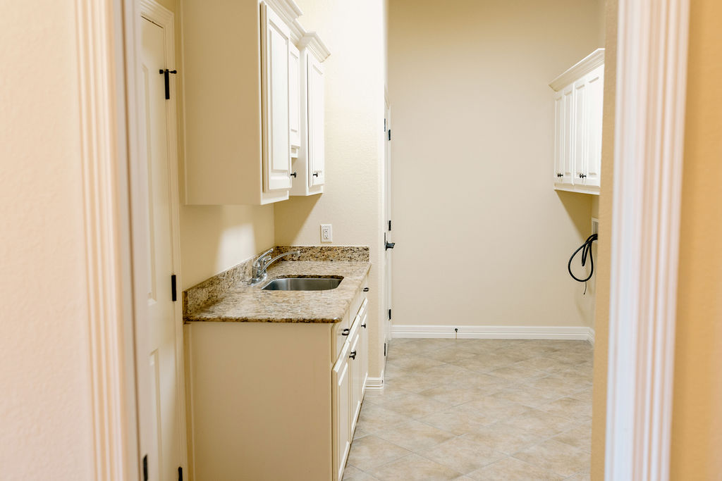 1909 Debbie Drive Bryan, TX 77802 - Photo 17 of 34 a bathroom with a granite countertop sink and a washing machine