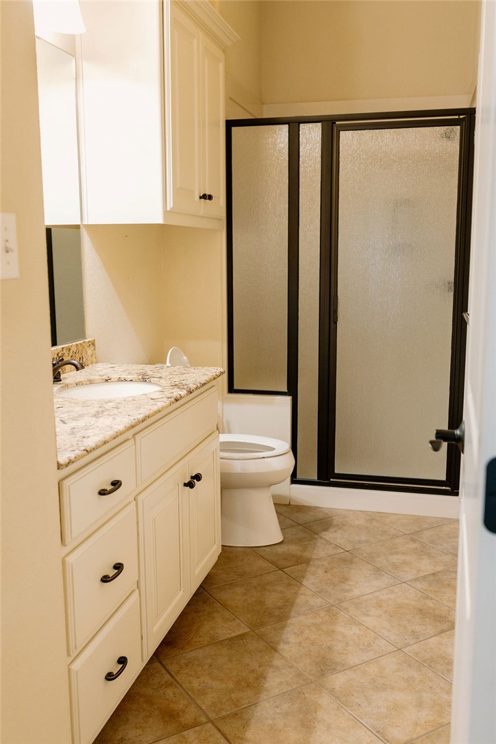 1909 Debbie Drive Bryan, TX 77802 - Photo 22 of 34 a bathroom with a granite countertop sink mirror vanity and toilet