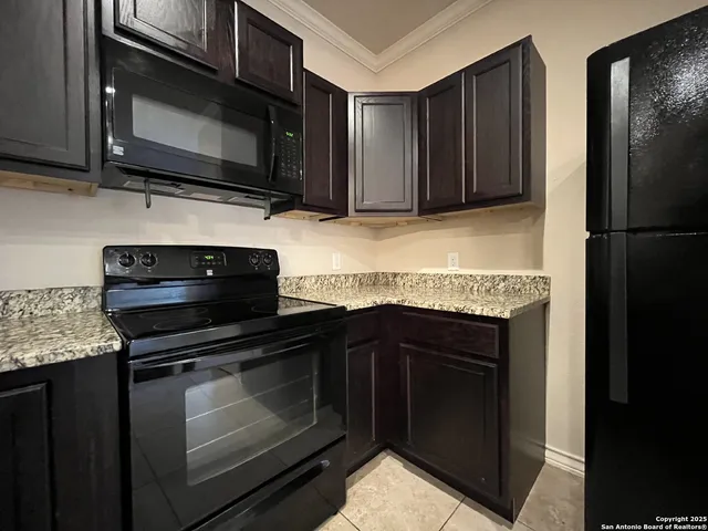 a kitchen with granite countertop wooden cabinets and stainless steel appliances