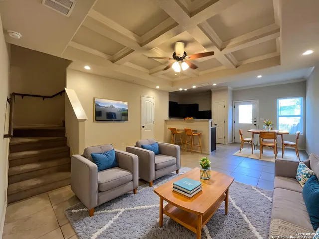 a living room with furniture a flat screen tv and kitchen view