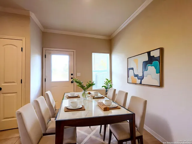 a view of a dining room with furniture and a potted plant