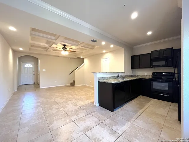 a large kitchen with granite countertop a sink and cabinets