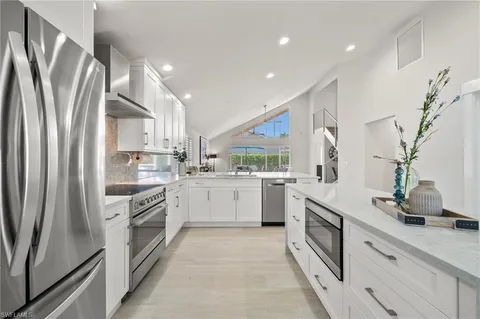 a kitchen with white cabinets and white appliances