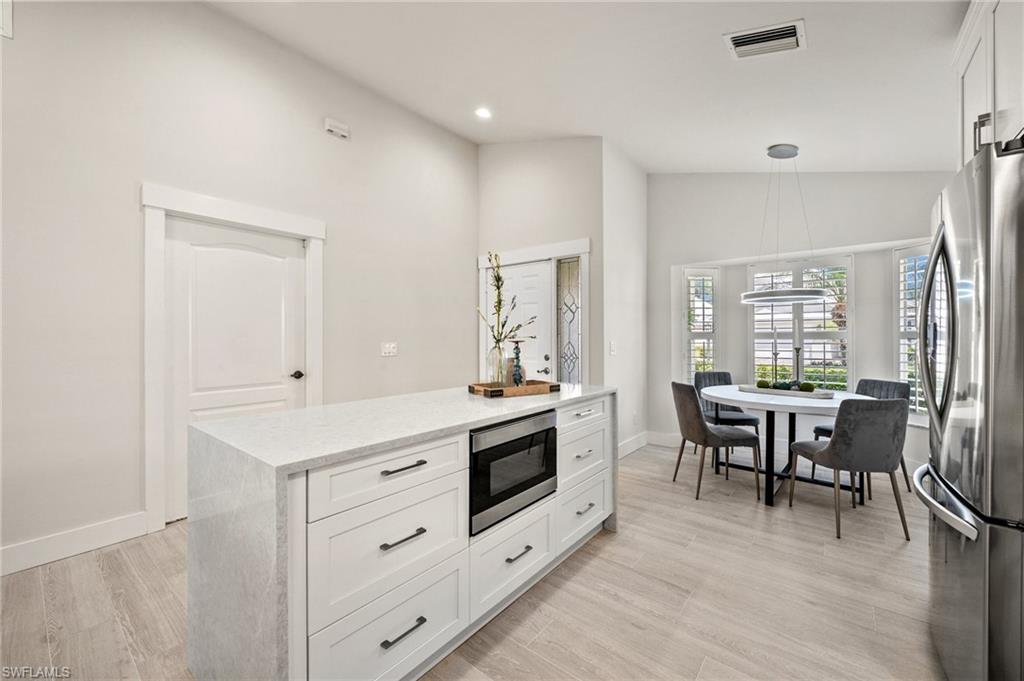 1590 Weybridge Circle, Unit 52 Naples, FL 34110 - Photo 12 of 36 a view of kitchen with furniture and wooden floor