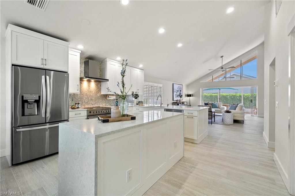 1590 Weybridge Circle, Unit 52 Naples, FL 34110 - Photo 13 of 36 a kitchen with refrigerator and cabinets